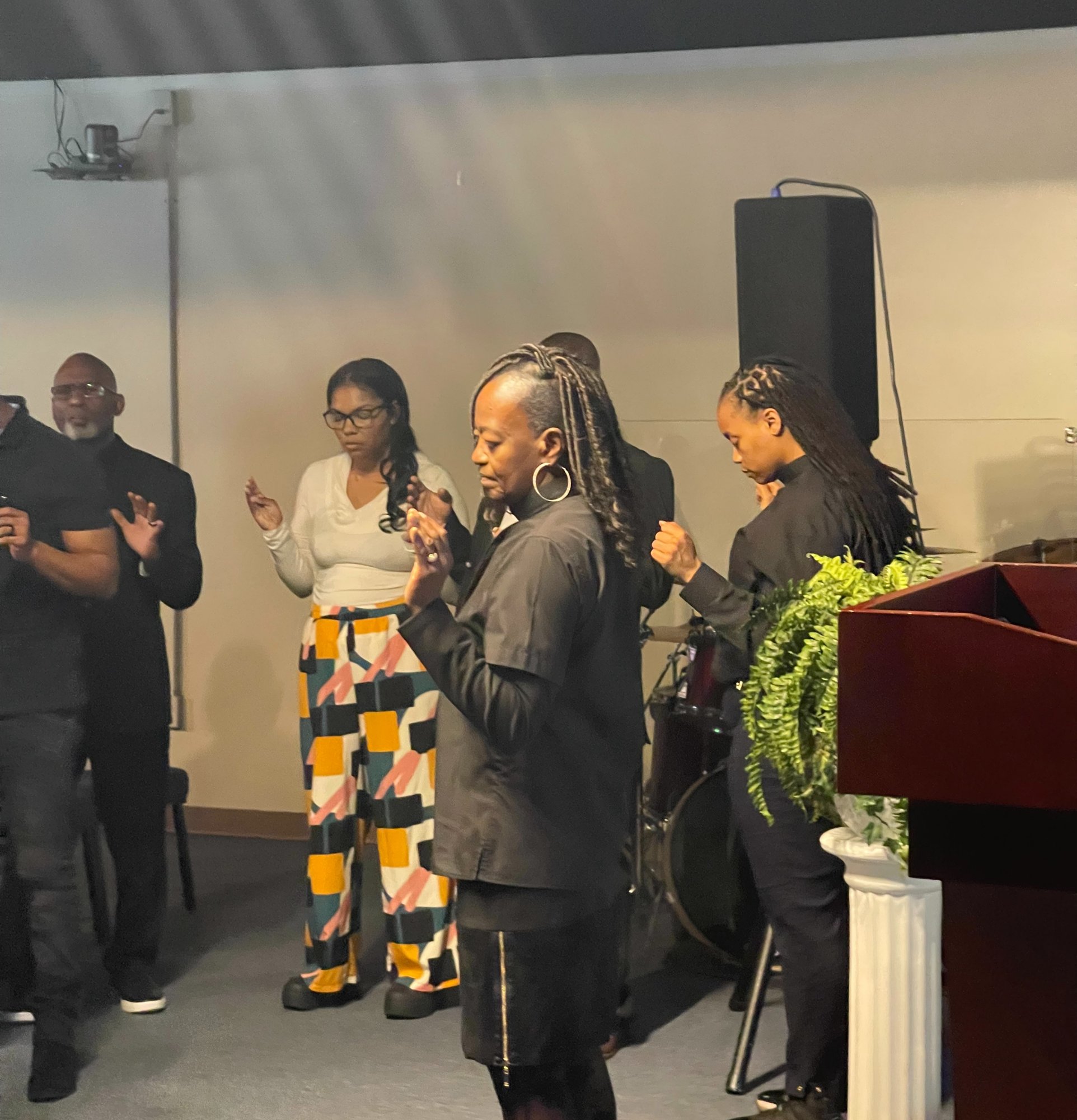 Members worshiping with hands lifted during service