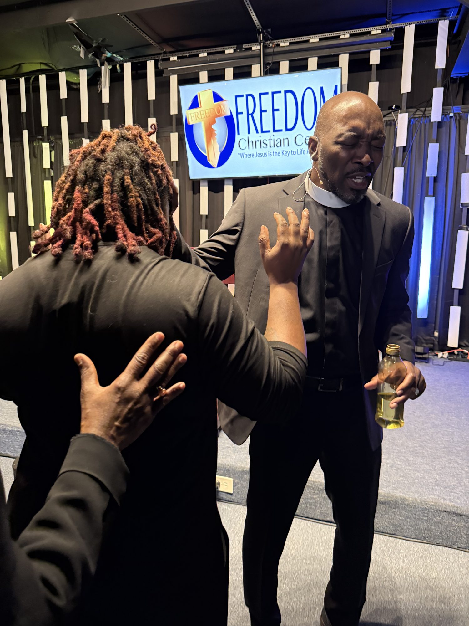 Pastor Shannon praying over a member at Freedom Christian Center